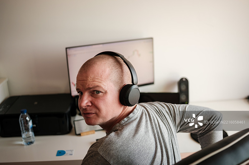 千禧一代投资者在家工作，收听财经新闻图片素材