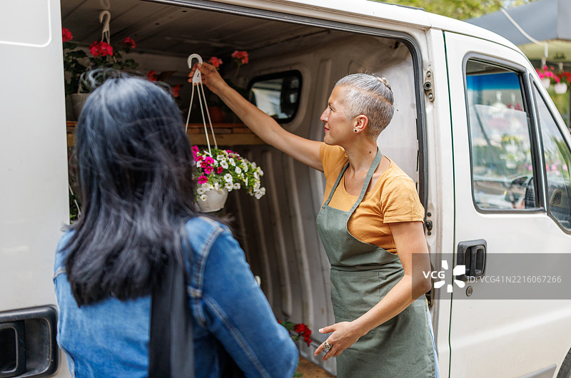 移动花卉摊位，悬挂花篮和盆栽植物图片素材