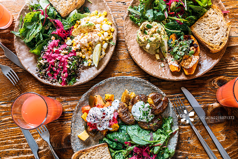 健康的素食菜肴在木桌上享用午餐，高角度视图图片素材