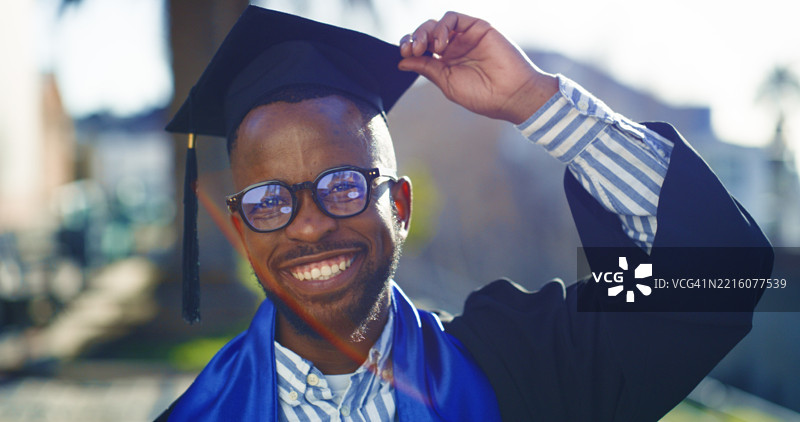年轻毕业生在户外庆祝学业成就，身穿学士服和学位帽图片素材
