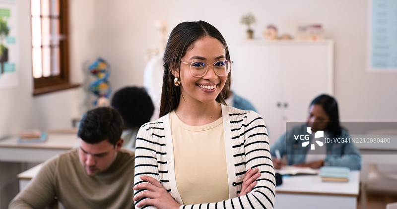 自信的学生在教室环境中，周围是专心学习的同学们。图片素材