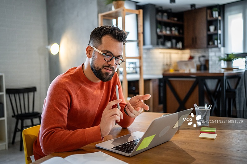 专注的年轻人在家工作，正在通过笔记本电脑进行视频通话图片素材