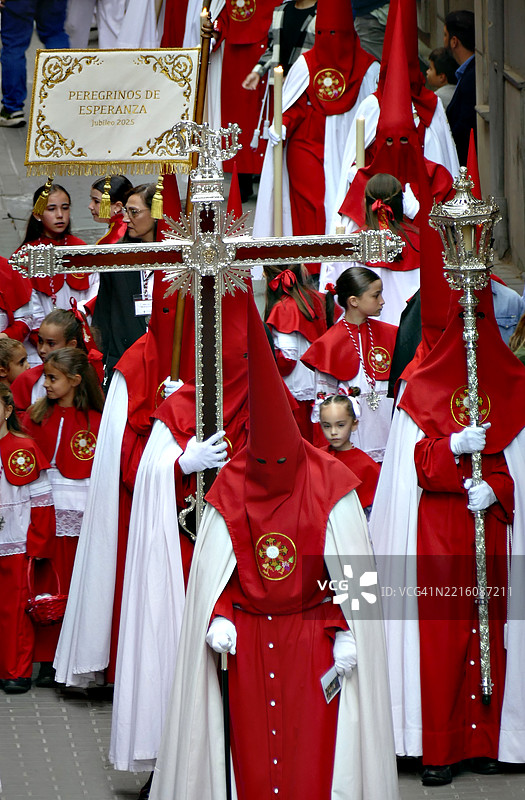 背负十字架。西班牙的复活节游行。忏悔者在格拉纳达的圣周游行中戴着尖顶红色头罩。图片素材