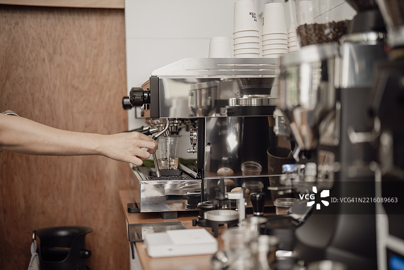 咖啡师特写镜头，准备研磨咖啡以提取浓缩咖啡。图片素材