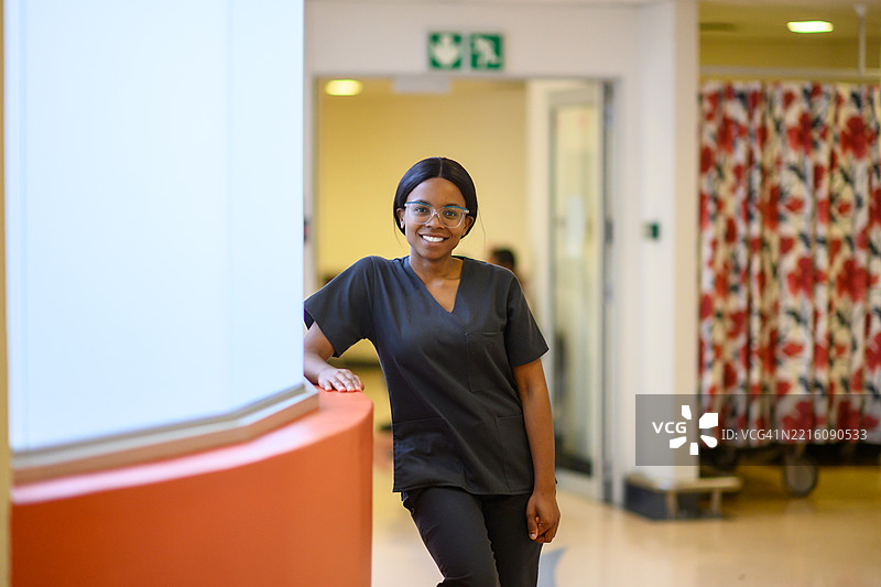 微笑的年轻医学生自信地站在医院走廊里图片素材