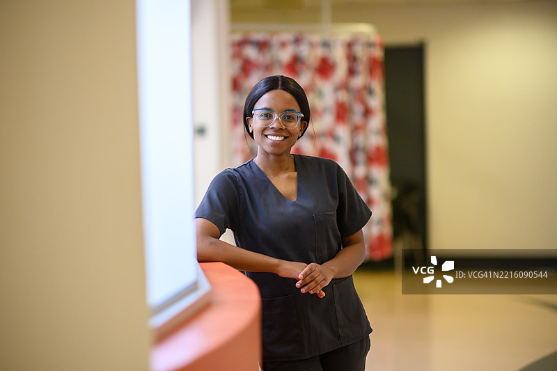 自信的年轻医疗专业人员穿着手术服站在医院走廊里图片素材