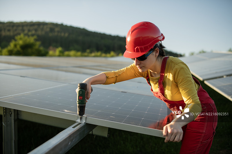 女工作人员正在光伏公园安装太阳能电池板。图片素材