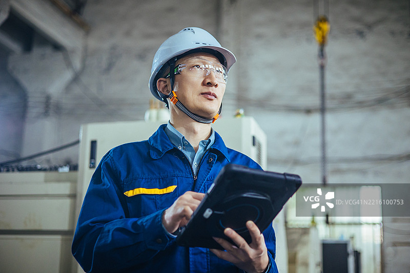 一位亚洲工程师在工厂使用平板电脑图片素材