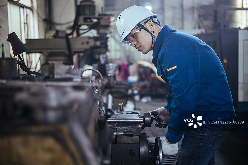 亚洲男性工程师在车床上工作图片素材