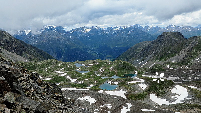 阿尔卑斯山的山地风景，带有小湖泊和雪，泽尔内茨，格里松，瑞士图片素材