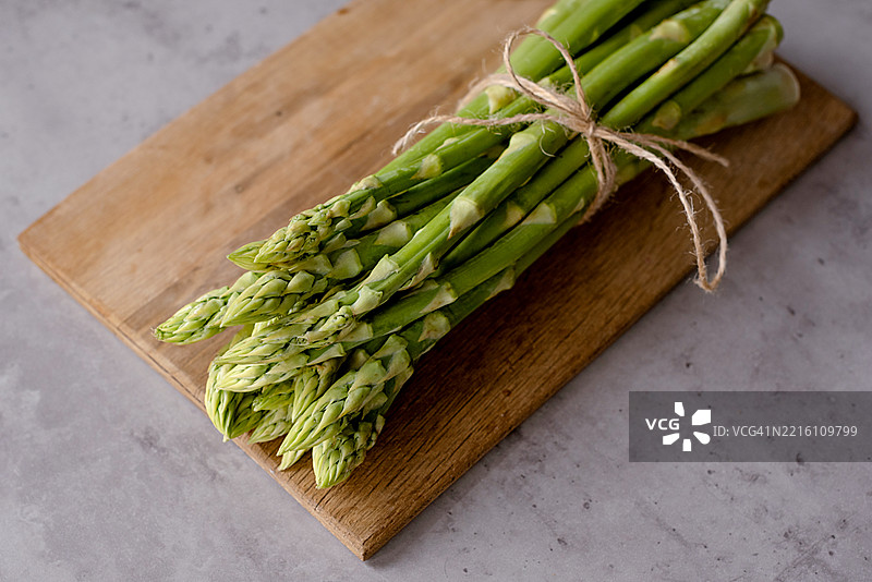 木质切菜板上的绿色芦笋图片素材