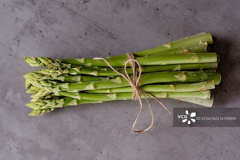 新鲜芦笋束在灰色背景上图片素材
