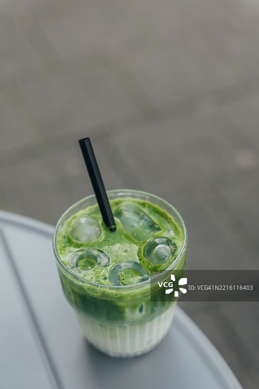 冰镇抹茶拿铁配黑色吸管放在桌子上图片素材