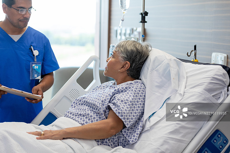 医生在医院病床上咨询年长女性患者图片素材