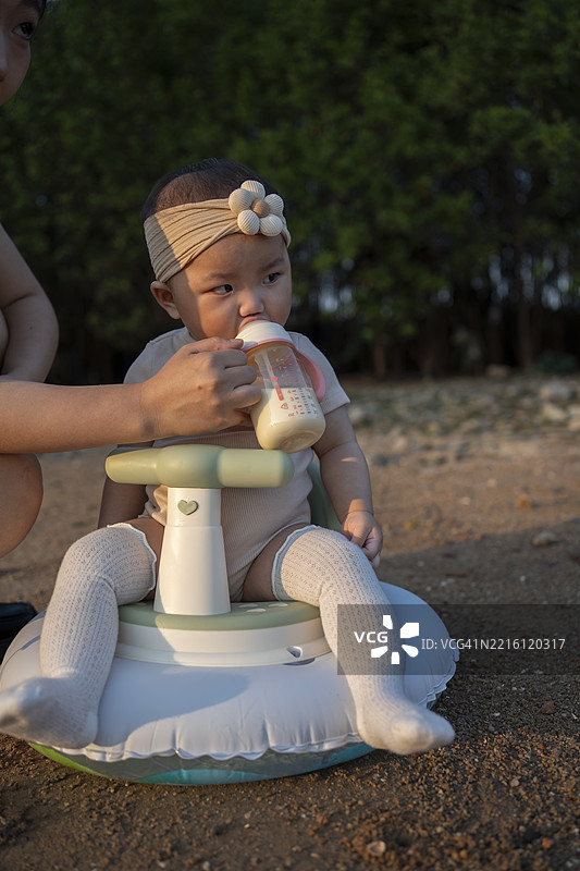 母亲在海滩上喂养她的宝宝图片素材