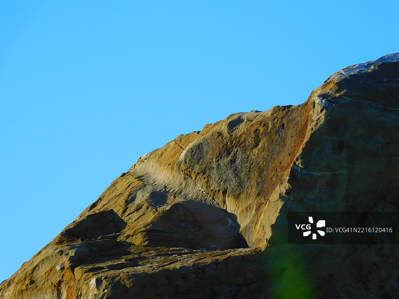 低角度视图下的岩石形成与晴朗的蓝天相映衬图片素材