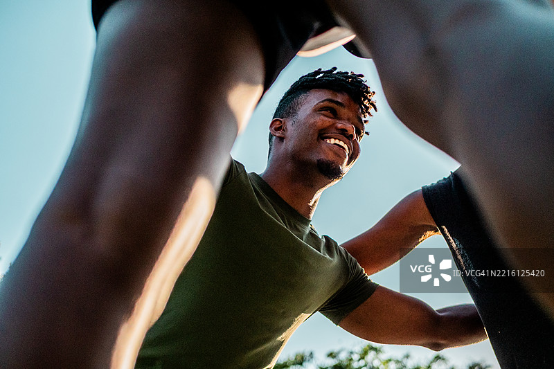 年轻男子与朋友们在户外拥抱图片素材