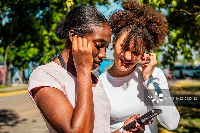 年轻朋友在公园里使用手机图片素材