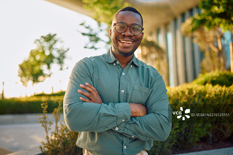 微笑的商人户外交叉双臂站立的肖像图片素材
