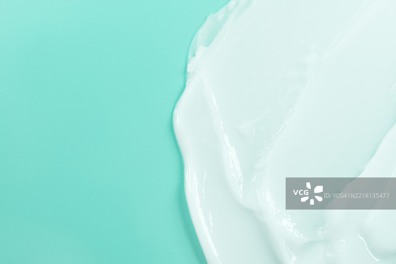 奶油质感的淡绿色背景上突显光滑的白色产品图片素材