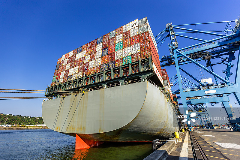 阳光明媚的日子，停靠在华盛顿塔科马港的大型货船与集装箱图片素材
