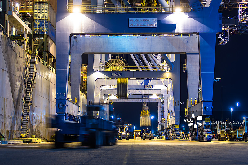 模糊运动镜头的卡车在华盛顿州塔科马的集装箱码头夜间行驶图片素材