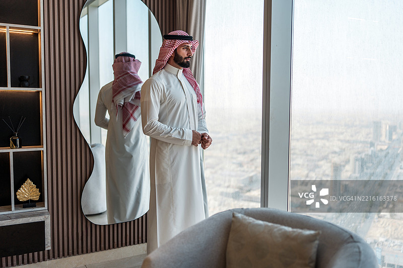 专注的年轻阿拉伯商人俯瞰利雅得天际线图片素材