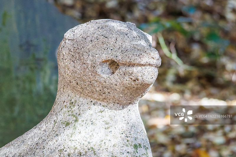 照片展示了公园内的小塔罗稻荷神社。穿过一座古老的鸟居，攀爬覆盖着苔藓的台阶，可以找到一座古老的神社和其他建筑。精美雕刻的狛犬（守护犬）也在其中。图片素材