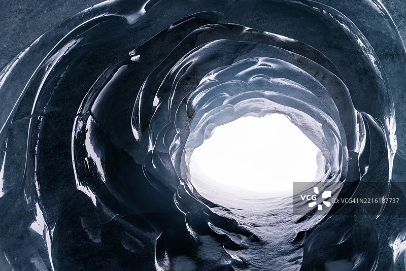 外部光线透过瑞士莫特拉茨冰川冰洞的孔洞进入。图片素材