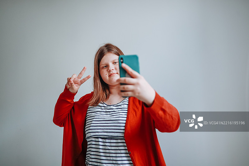 胖女孩在白色墙壁前自拍图片素材