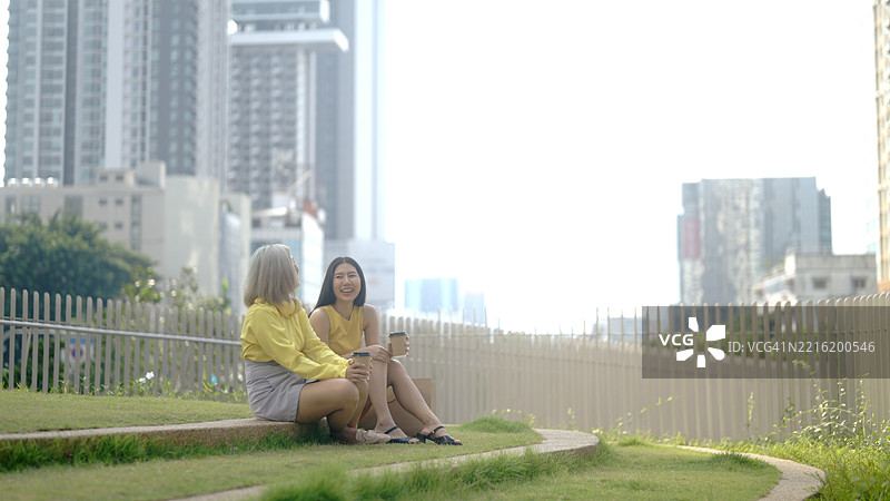 两位女士在欢笑中散步。图片素材