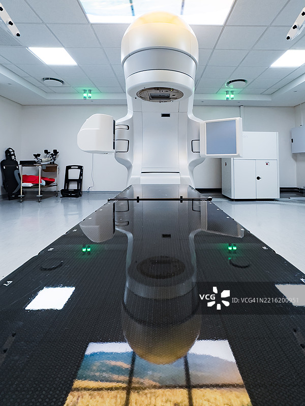 现代放射治疗机位于一个先进且无菌的医疗治疗室内图片素材