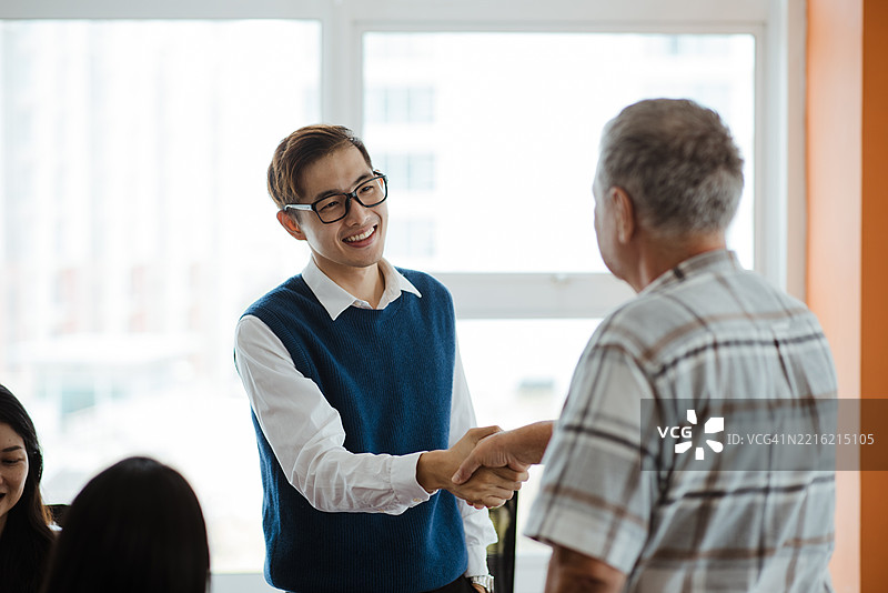 快乐的男性程序员在办公室互相问候图片素材