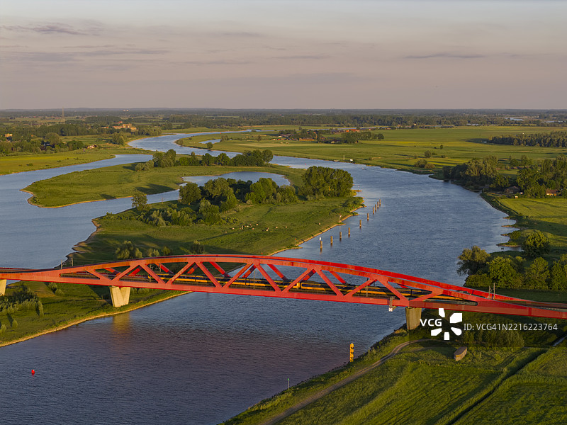 彩色日落下的IJssel河上的火车桥图片素材