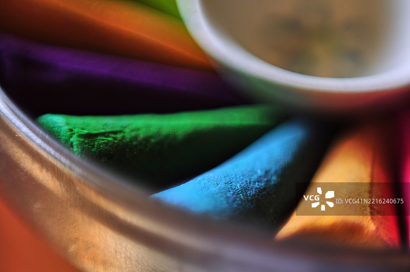 一个容器里装着几根彩色的香。图片素材