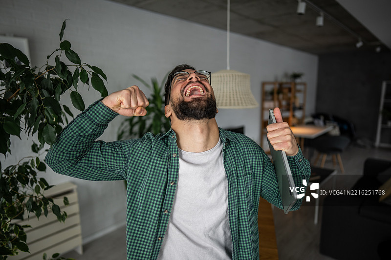 兴奋的自由职业者在家庆祝成功图片素材