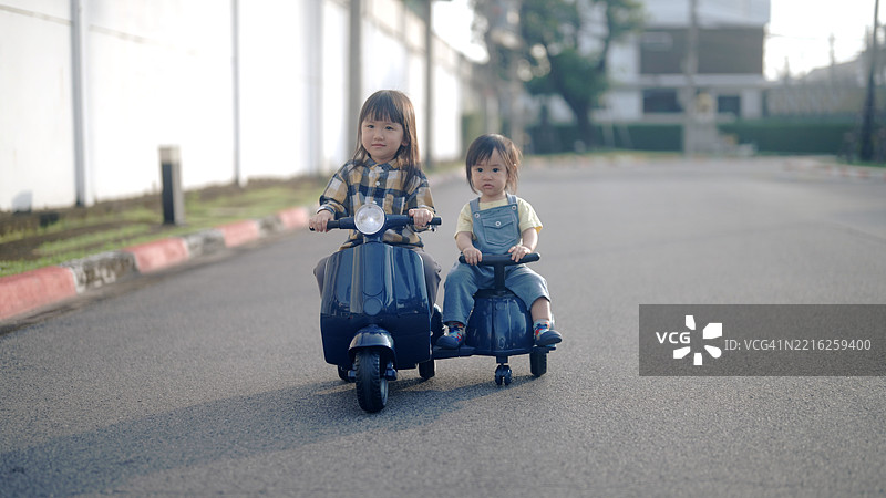 兄弟姐妹们玩得开心，玩着玩具汽车图片素材