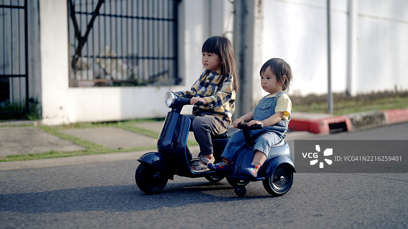 兄弟姐妹们玩得开心，玩着玩具汽车图片素材