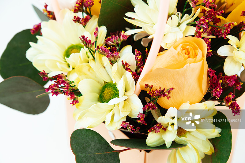 一束装饰性的花束，包含黄色郁金香和白色菊花。图片素材