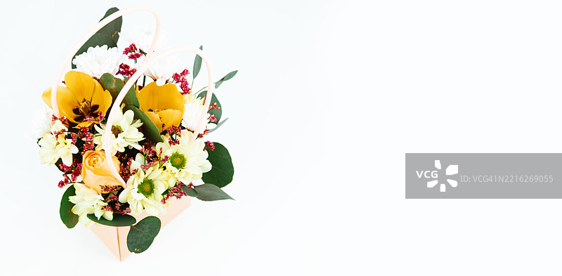 一束装饰性的黄郁金香和白菊花的花束。图片素材