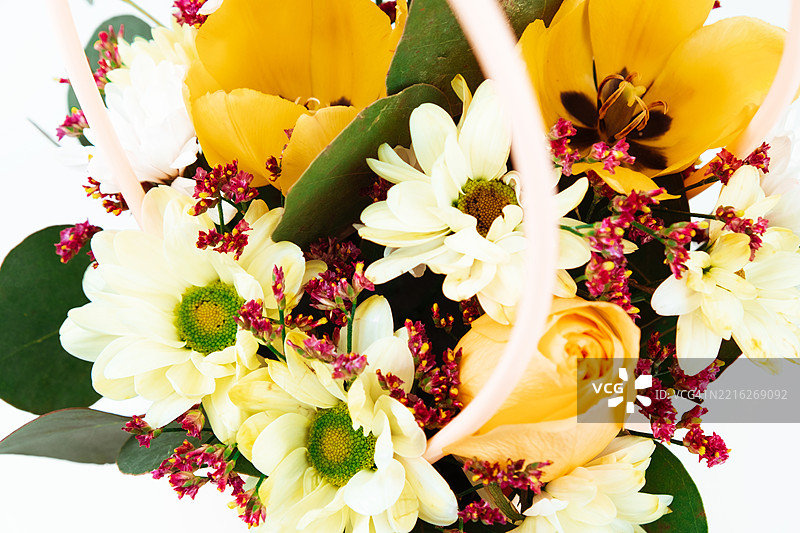 一束装饰性的黄郁金香和白菊花的花束。图片素材