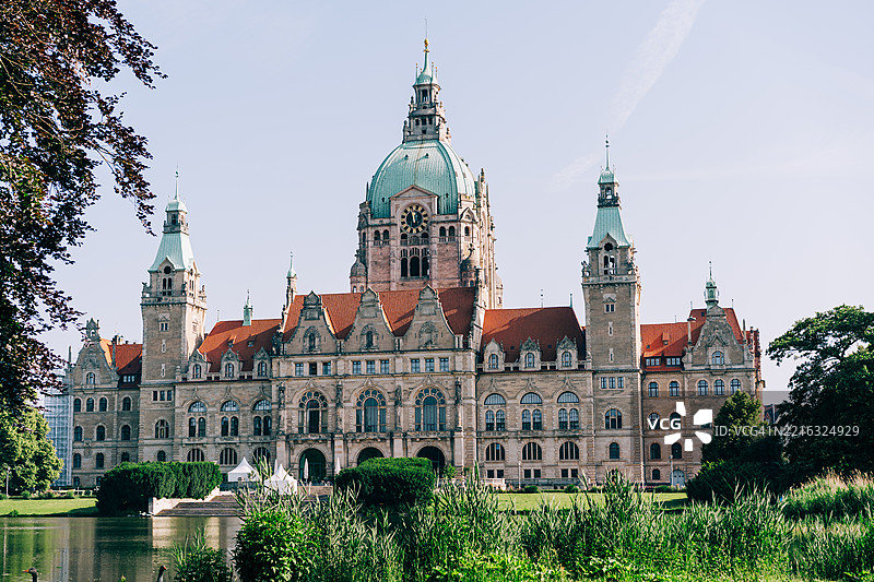 汉诺威，德国，晴朗的日子里被绿树环绕的宏伟历史新市政厅大楼图片素材