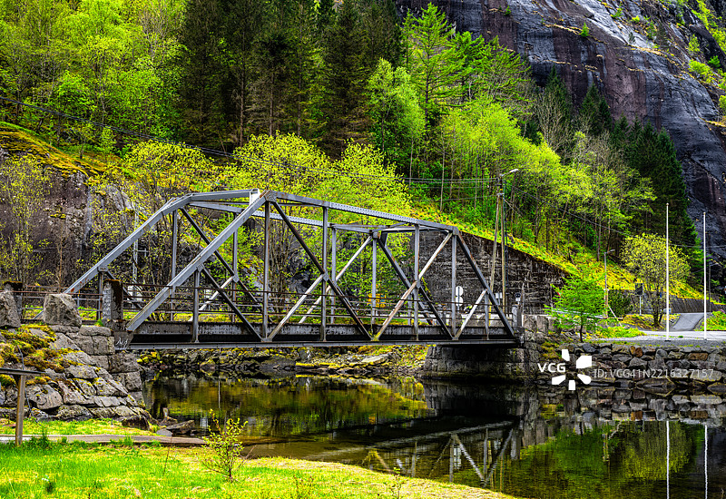 一座钢桥横跨河流，在水面上形成美丽的倒影。图片素材