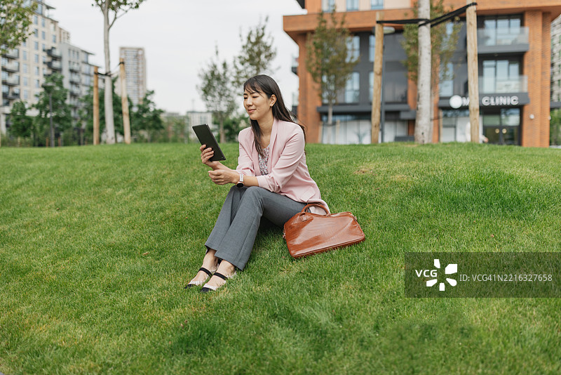 专注的女性在户外享受数字平板电脑图片素材
