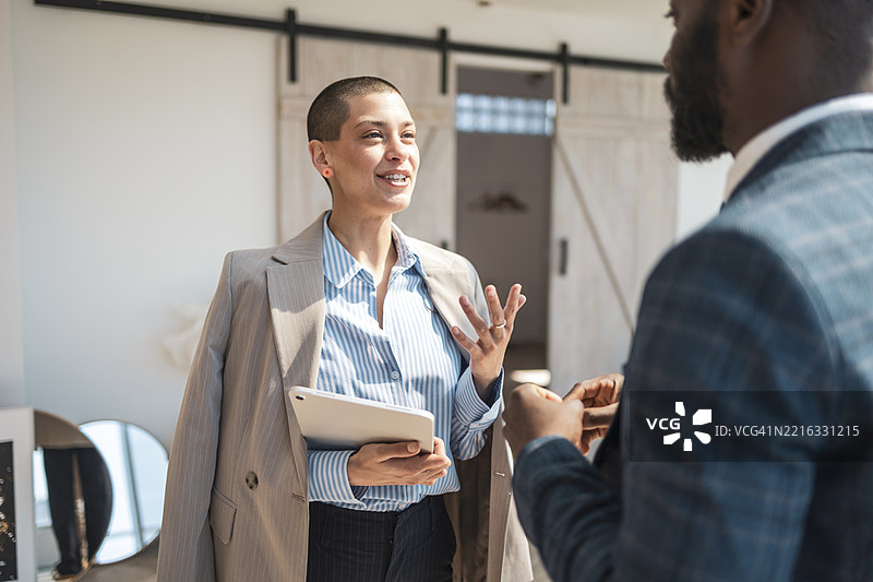 自信的专业人士在明亮的现代办公室环境中讨论业务图片素材