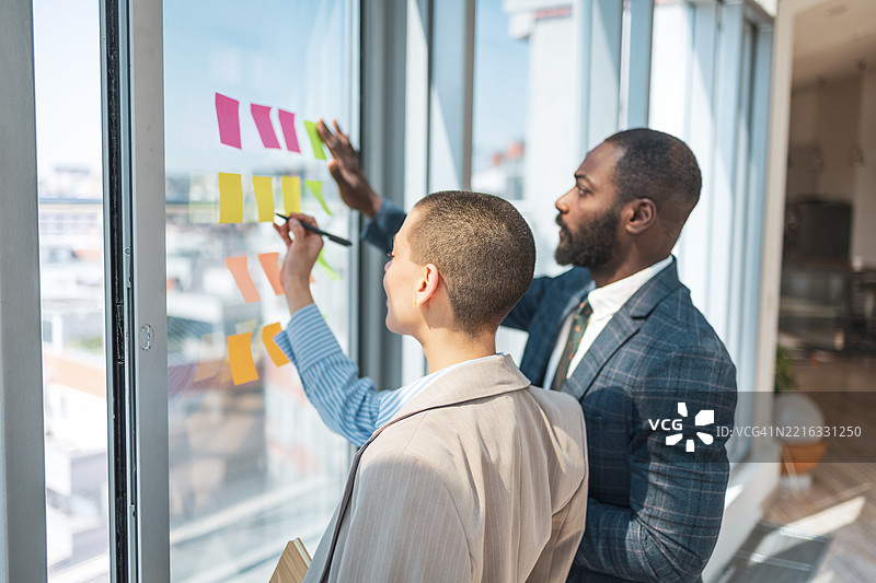 专业人士在现代办公室环境中合作进行创意项目图片素材