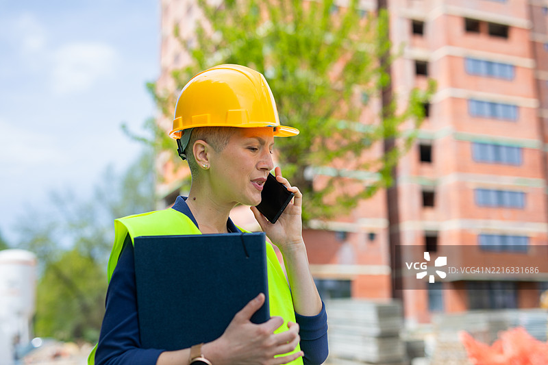 女性主管在建筑工地前打电话图片素材