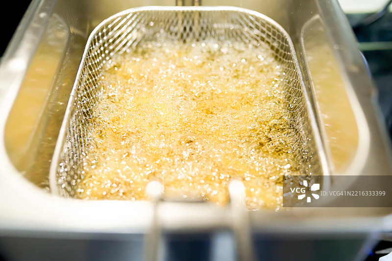 深炸锅篮中沸腾的油正在烹饪食物图片素材