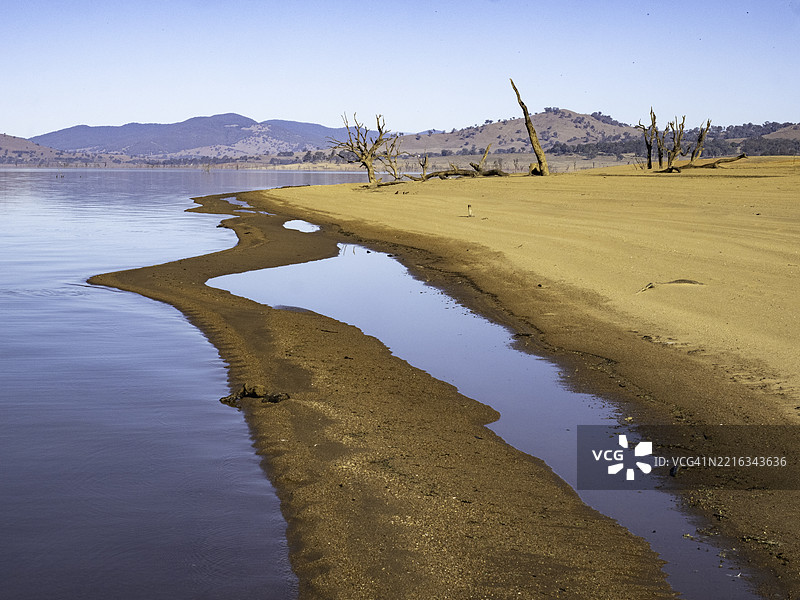 傍晚的阳光照耀在倒影湖和红色沙滩上图片素材