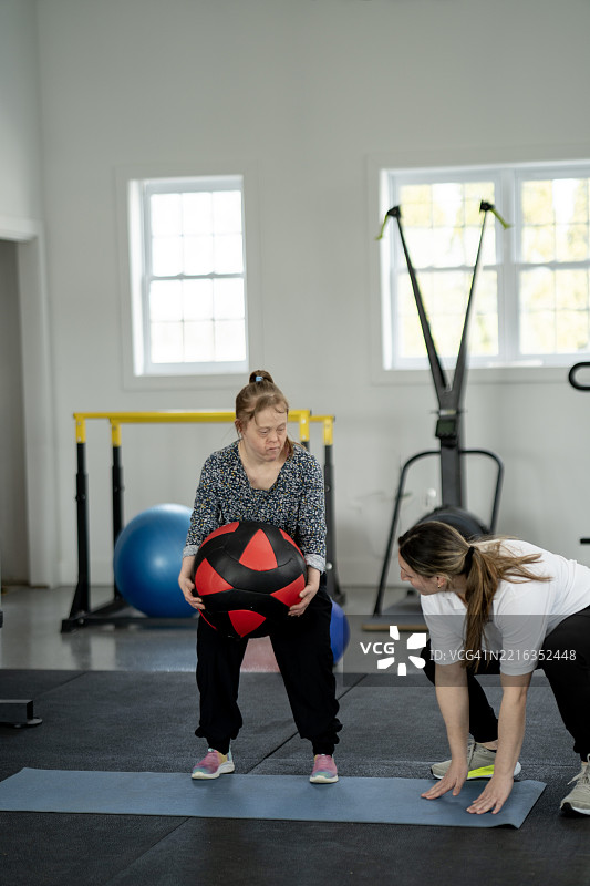 治疗师在身体训练课程中协助特殊需要人士图片素材